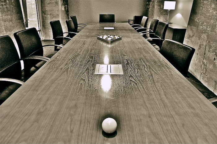 A long conference table in a board room.