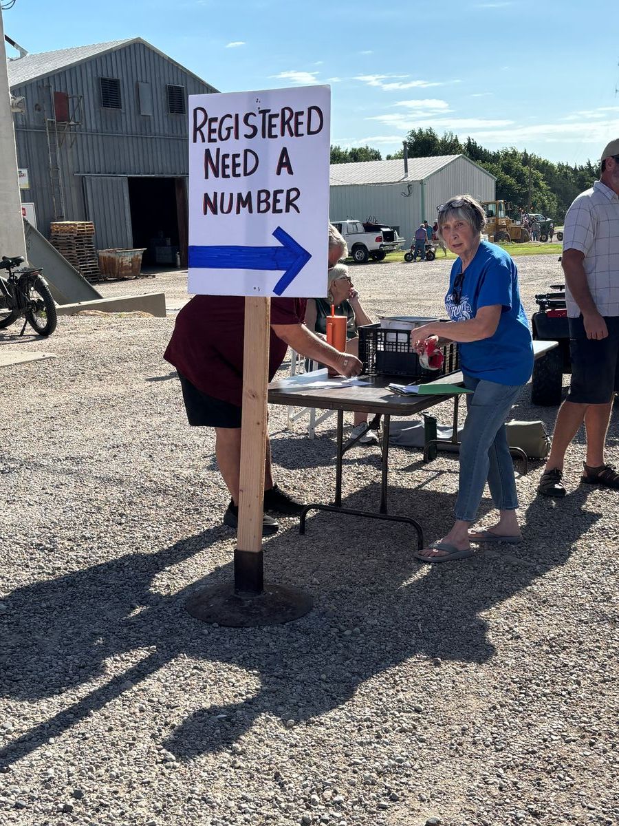 Getting Parade Entries registered. LaRue C and Buddy S (Behind sign), sitting Chris S & far right Jess M