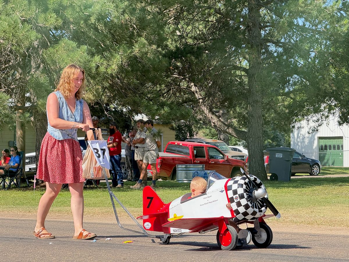 Parade Entry: Maggie pushing her son in the Burkhart Boys Plane. Parade Prize Winner