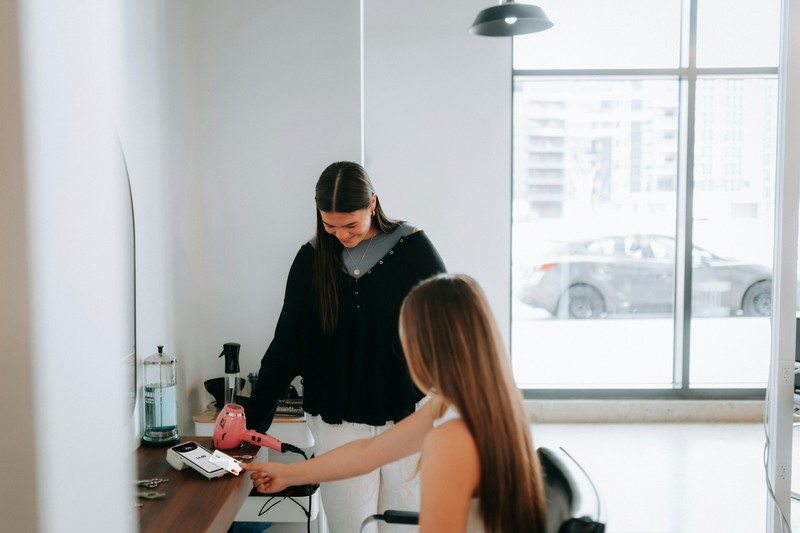 Hairstylist working on a client's hair in a salon chair