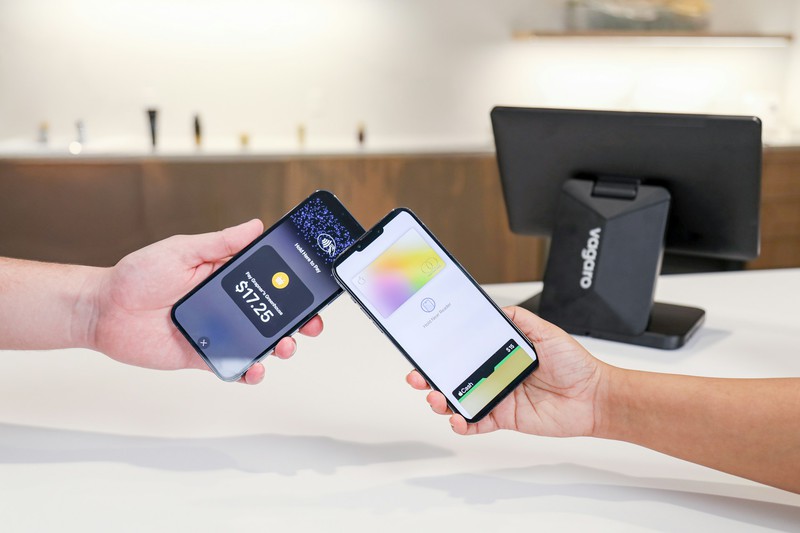 Two phones being used for a contactless payment at a salon checkout