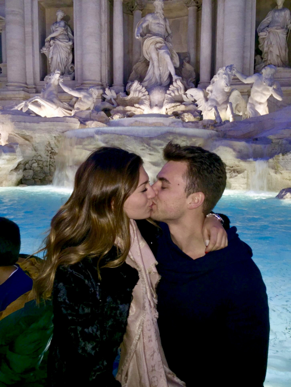 an oil painting of a couple by the fountain statues