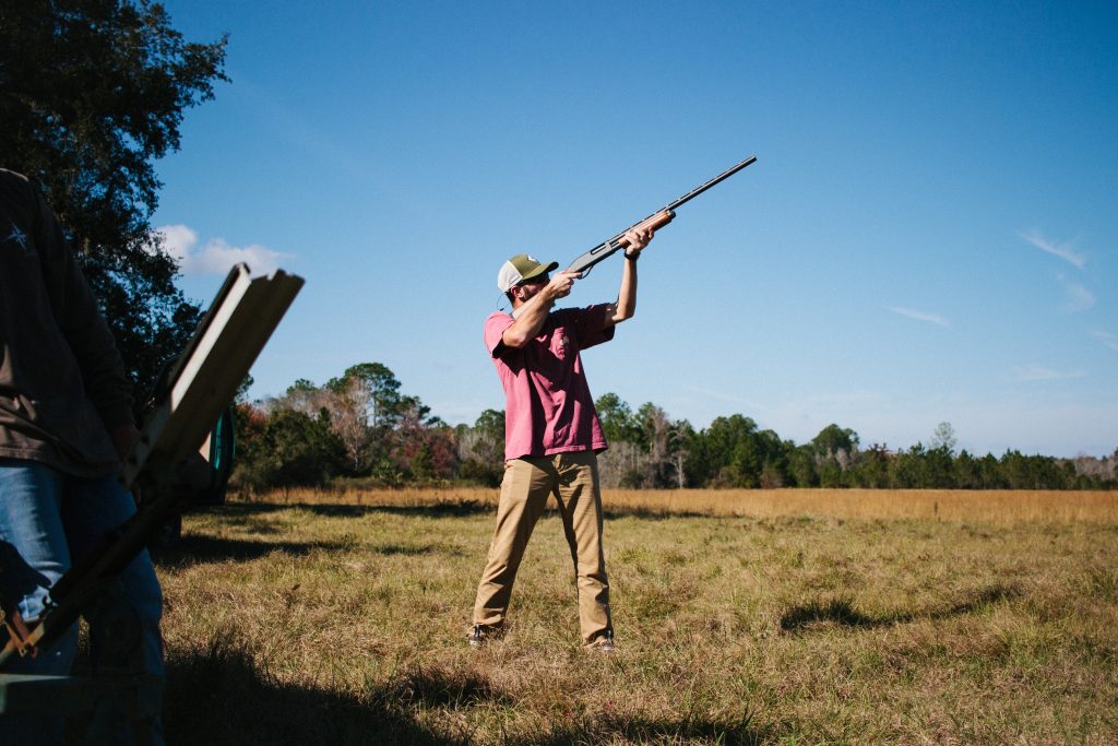 A hunter practicing his marksmanship by shooting clay pigeons.
