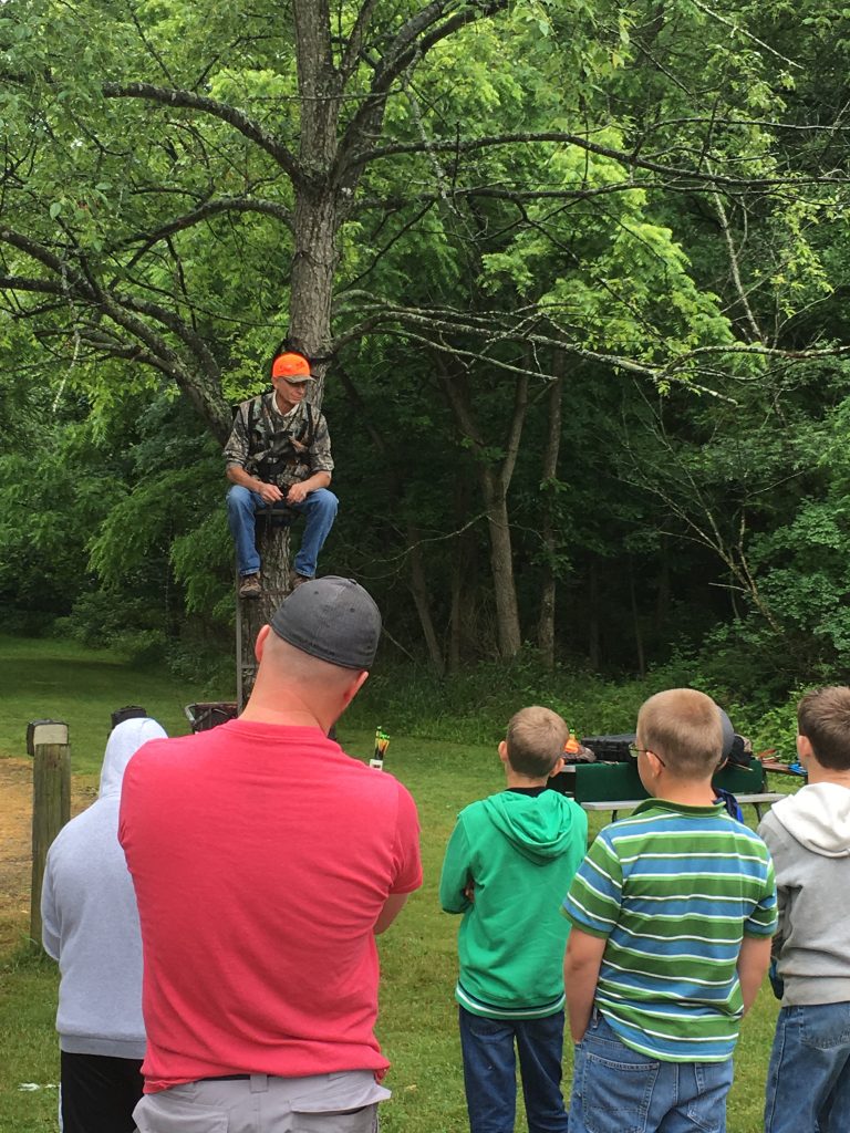A hunter safety teacher demonstrates a tree stand for deer hunting.