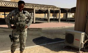 Woman soldier standing hands on her hips at the camera