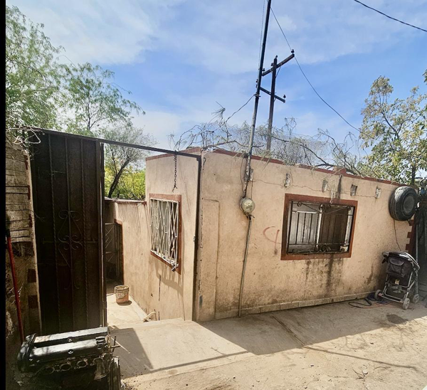 Terreno con construcción de adobe y techo de vigas.