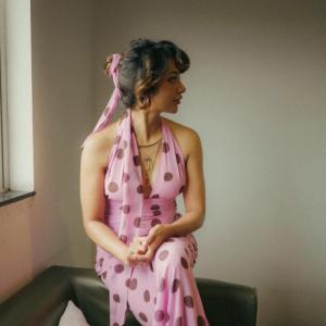 Tejaswi Madiwada in a Chic Pink Polka Dot Dress - Elegant and Thoughtful Portrait