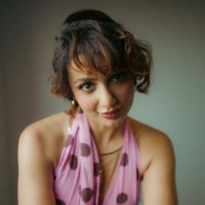 Tejaswi Madiwada in a Chic Pink Polka Dot Dress - Elegant and Thoughtful Portrait