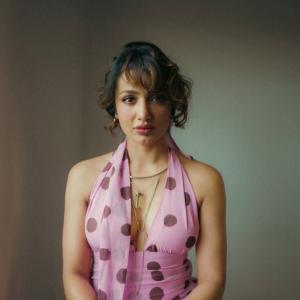 Tejaswi Madiwada in a Chic Pink Polka Dot Dress - Elegant and Thoughtful Portrait