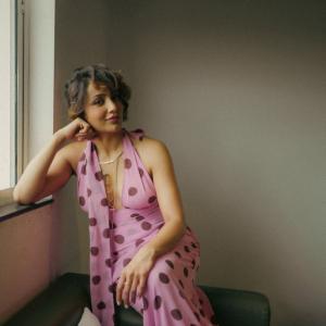 Tejaswi Madiwada in a Chic Pink Polka Dot Dress - Elegant and Thoughtful Portrait