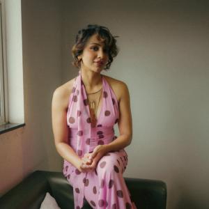 Tejaswi Madiwada in a Chic Pink Polka Dot Dress - Elegant and Thoughtful Portrait