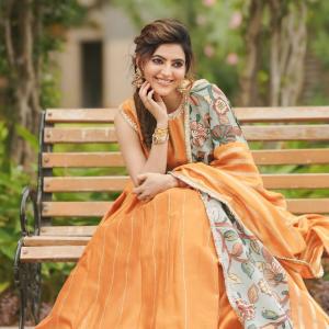 Elegant Portrait of Actress Athulya Ravi in Orange Traditional Outfit with Floral Dupatta