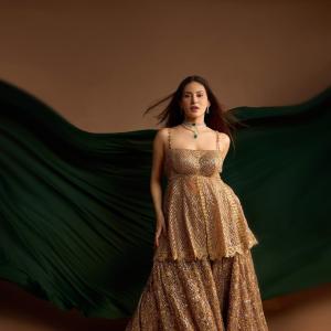 Elegant Golden Sequined Dress with Green Backdrop - Fashion Photoshoot