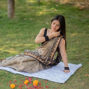 Actress bandhavi sridhar in a traditional black and beige saree look outdoors