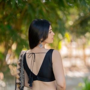Actress bandhavi sridhar in a traditional black and beige saree look outdoors