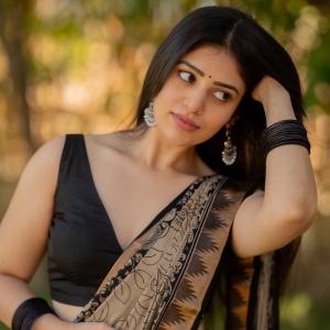 Actress bandhavi sridhar in a traditional black and beige saree look outdoors