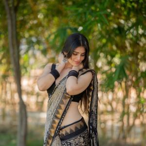 Actress bandhavi sridhar in a traditional black and beige saree look outdoors