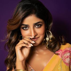 Actress Dimple Hayathi in a yellow floral saree photoshoot against purple background