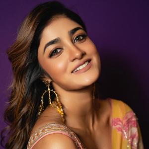 Actress Dimple Hayathi in a yellow floral saree photoshoot against purple background