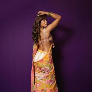 Actress Dimple Hayathi in a yellow floral saree photoshoot against purple background