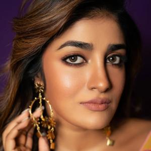 Actress Dimple Hayathi in a yellow floral saree photoshoot against purple background