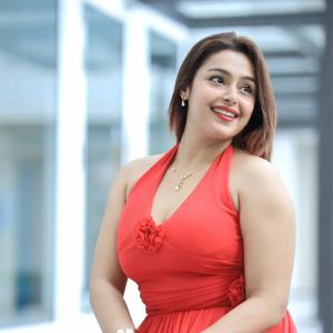 Actress Mokksha Stuns in a Vibrant Coral Red Midi Dress