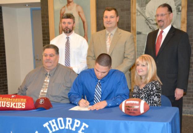 Jim Thorpe's Kevin Vitti, seated center, signs letter of intent to play football and continue his education at Bloomsburg University. He had played for the Jim Thorpe Olympians. Seated with him are his parents, Alex and Linda Vitti. In back are,…