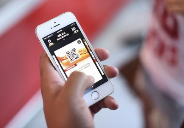 In this Sept. 14, 2014, photo, a fan uses an app on a smartphone to order food and drinks at Levi's Stadium during an NFL football game between the San Francisco 49ers and the Chicago Bears in Santa Clara, Calif. (AP Photo/Noah Berger)