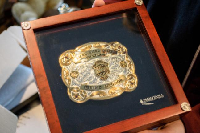 Sarah displays a belt buckle she won in metric position competition in Indiana. She participated in the two-day competition, shooting 120 shots at 50 meters.
