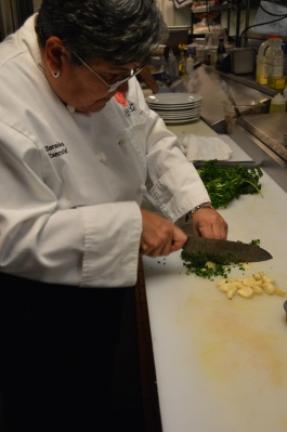 Rivera chops parsley and garlic to make the Chimichurri sauce.