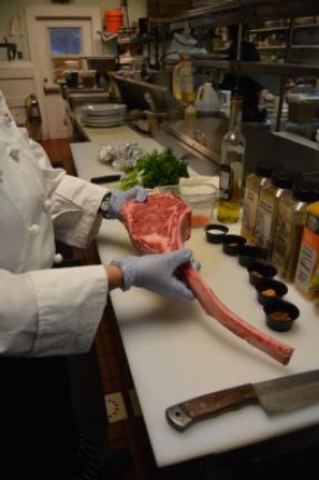 Chef Zoraida Rivera displays a raw tomahawk steak, which is a bone-in ribeye with a rib bone of about 20 inches. KAREN CIMMS/TIMES NEWS