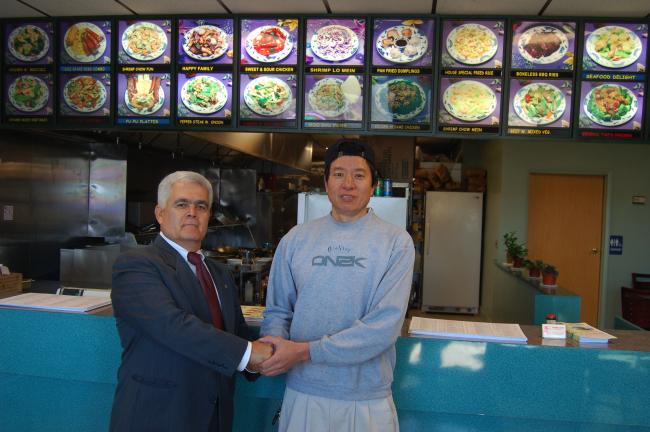 JOE PLASKO/TIMES NEWS Tony Lin (right), owner of China City in the Village Centre Mall, Snyders, is welcomed to West Penn Township by Supervisor Alfonso Martinez.