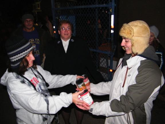 ANDREW LEIBENGUTH/SPECIAL TO THE TIMES NEWS Tamaqua 11th grade student Spencer Bennett, 17, right, accepts food drive donations from Alexandra Miller, 14. Tamaqua Salvation Army soldier and volunteer Mary Hosler is in the middle.