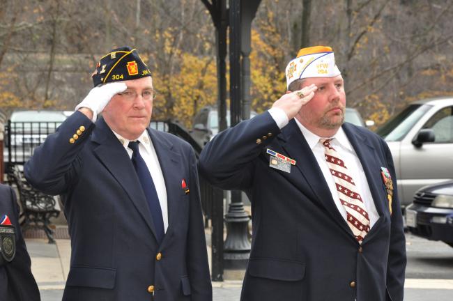 AMY ZUBEK/TIMES NEWS Martin Golden, Sgt. at Arms for American Legion Post 304 in Jim Thorpe; and Gilbert Henry, member of American Legion Post 304 and VFW Post 294 in Albrightsville, salute the American flag during Carbon County's Veterans Day…