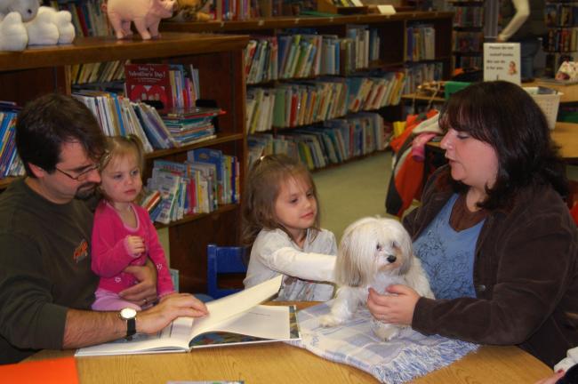 ELSA KERSCHNER/TIMES NEWS Grant Stauffer reads "Where the Wild Things Are" as his preschoolers, Serena and Jocelyn, listen along with Angel Cake.