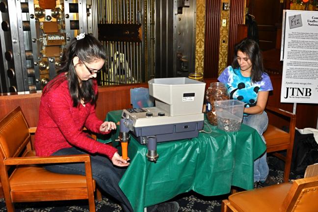VICTOR IZZO/SPECIAL TO THE TIMES NEWS At the JTNB's main office on Broadway, Jim Thorpe Area High School Seniors Amanda Kattner (left) and Danaee Mullen, working on their Senior graduation project, tally the money collected for UNICEF with the…
