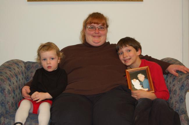CHRIS PARKER/TIMES NEWS Michele Fredericks of Lehighton sits with her children, Jenna, left, and Jon, 7, who is holding a photograph of himself as a newborn being held by his late father, Jan H. Ahner.