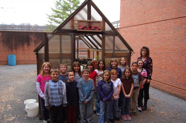 LINDA KOEHLER/TIMES NEWS Advisor Mrs. Sue Mendes and some members of the third and fourth grades students of the Garden and Environmental Club at Slatington Elementary School take time to show a visitor their greenhouse in the school's courtyard…
