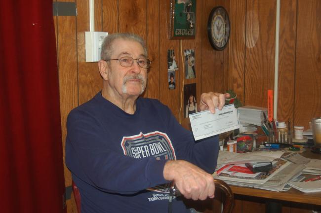CHRIS PARKER/TIMES NEWS Navy veteran Richard McGinley, 73, of Lehighton, holds the "sweepstakes" check he received in the mail.