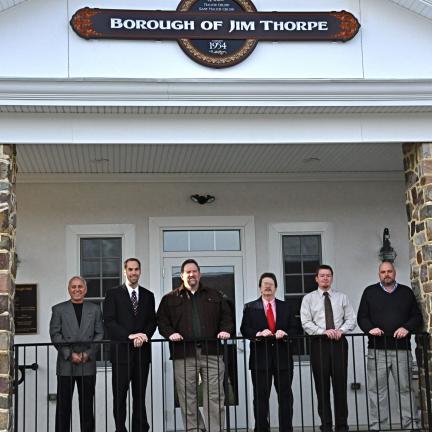 VICTOR IZZO/SPECIAL TO THE TIMES NEWS Standing beneath the new Borough of Jim Thorpe sign on the front of the new office building and police station are, from left, Mayor Ronald Confer, Councilman Jeremy Melber, council President John McGuire,…