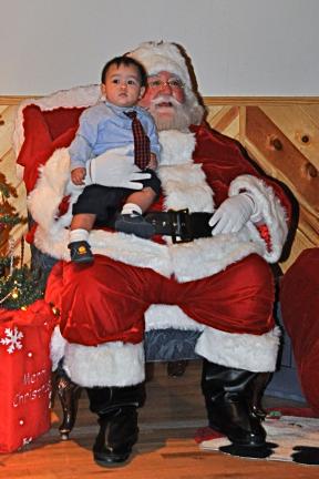 VICTOR IZZO/SPECIAL TO THE TIMES NEWS Chase Slanina, 10 1/2 months, keeps an eye on his Dad and Mom, John & Nuchanat Slanina of Palmerton during his visit with Santa Claus at Penn's Peak.