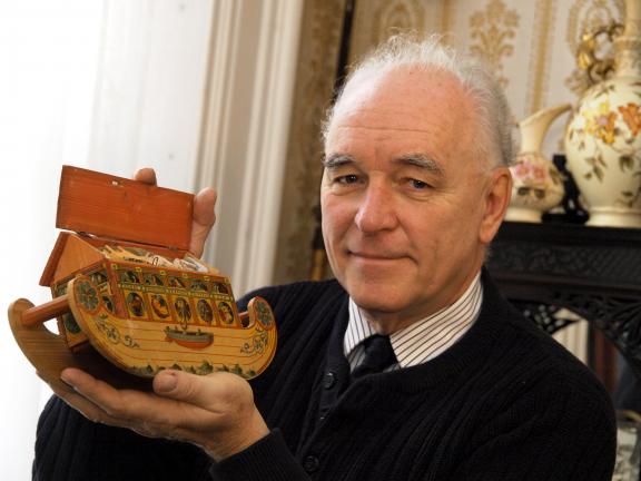 AL ZAGOFSKY/SPECIAL TO THE TIMES NEWS John Gunsser holds a late 19th century Noah's Arc toy. The toy, an inexpensive German assemblage of wood covered with a lithographed design, served to illustrate a Biblical lesson.