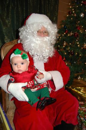 Gail Maholick/TIMES NEWS Stella Breiner, 4 months, and daughter of Ernie and Jordie Breiner of Lehighton is the pretty miss meeting Santa Claus for the first time. She was one of the 75 children attending the Breakfast with Santa, sponsored by the…