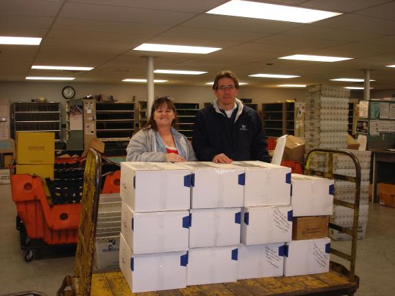 MARY TOBIA/SPECIAL TO THE TIMES NEWS St. John's Episcopal Church families sent care packages to thirteen military soldiers. Left to right-Deb Craig, Junior Warden of St. John's and Rich Wasser, Palmerton Postmaster finish the paper work for each box…