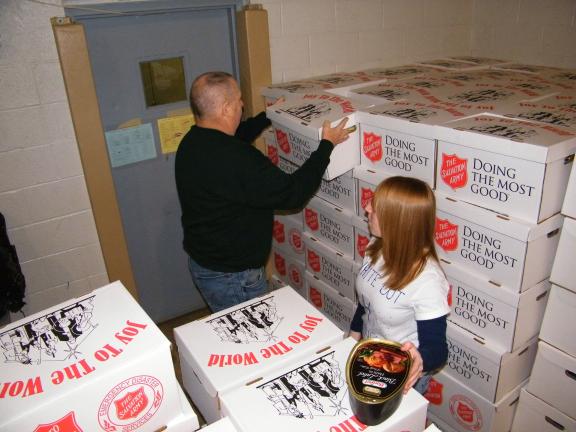 ANDREW LEIBENGUTH/SPECIAL TO THE TIMES NEWS Tamaqua Police Chief George Woodward, left, and Tamaqua Marketing Class volunteer Shauna Bannan help distribute Tamaqua Salvation Army food boxes and hams during the Tamaqua Salvation Army distribution.