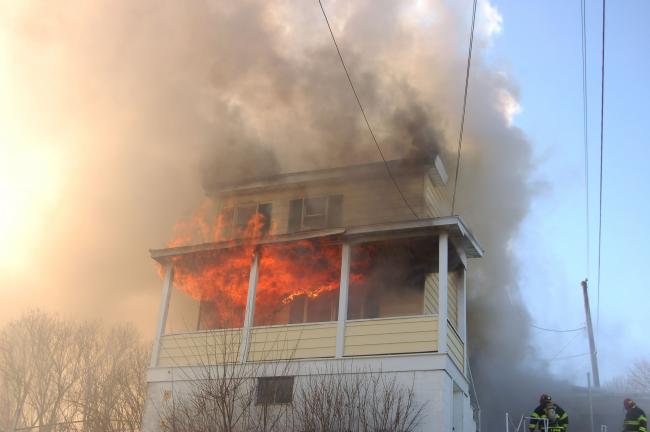 JOE PLASKO/TIMES NEWS Fire and smoke erupt from the front of the single family dwelling at 226 Washington Street, Tamaqua, the residence of David and Michelle Valentine. The family, which has eight children, was displaced by the Wednesday afternoon fire.