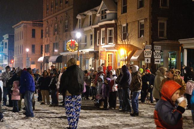 A large crowd gathers on a snowy East Broad St in Tamaqua on New Year's Eve in anticipation of the lighted "eagle flight" down the facade of the ABC High Rise Building as part of the borough's annual "Times Square on Broad Street" celebration.