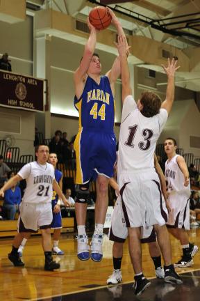 STEVE SHINKO/special to the times news Marian's Drew Sherkness (44) goes over Lehighton's JT Keer with a shot.