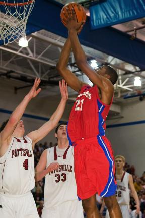 STEVE SHINKO/Special to THE TIMES NEWS Jim Thorpe's Rashid Epps goes to the basket in front of Pottsville defenders Bobby Schappell (4) and Nick Schlitzer (33) during Tuesday's District 11 Class AAA boys semifinal game at Blue Mountain High School…