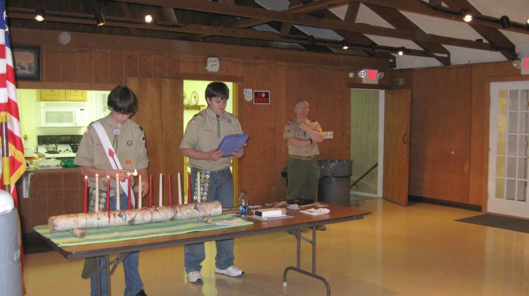 RICK GRANT/SPECIAL TO THE TIMES NEWS To open the ceremony, Assistant Senior Patrol Leader Steven Hutta lights one of 12 candles, each one representing one of the12 points of the Scout Law, as Senior Patrol Leader Tim Miller reads to parents and…